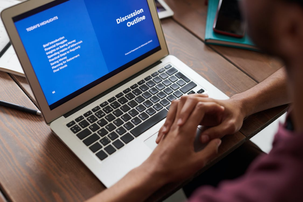 A kid sitting in front of their laptop that’s showing some text on a blue screen during an online class.